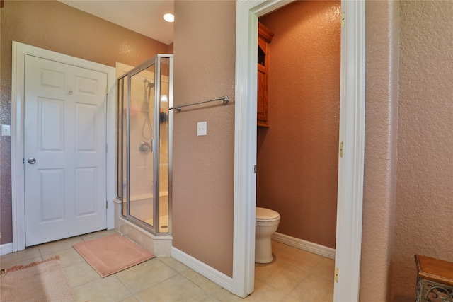 bathroom with tile patterned floors, a shower with shower door, and toilet