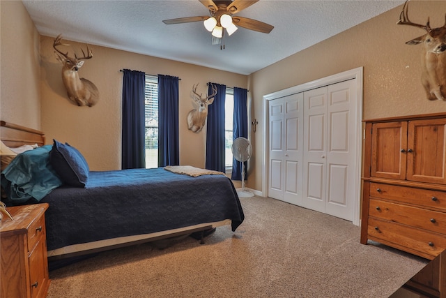 bedroom with ceiling fan, a textured ceiling, a closet, and carpet flooring