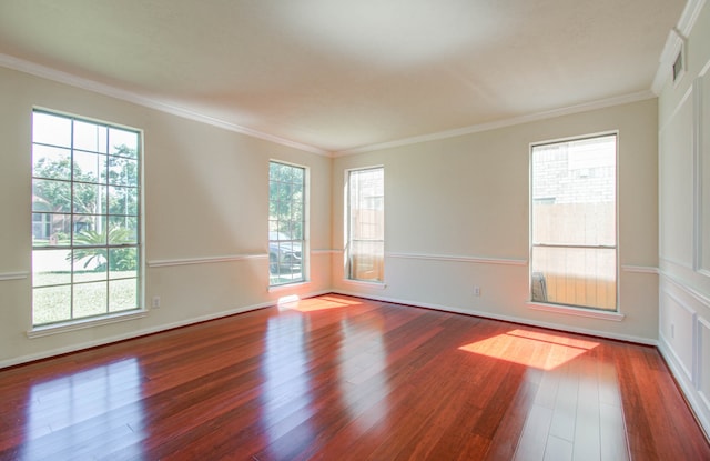 spare room with hardwood / wood-style flooring and crown molding