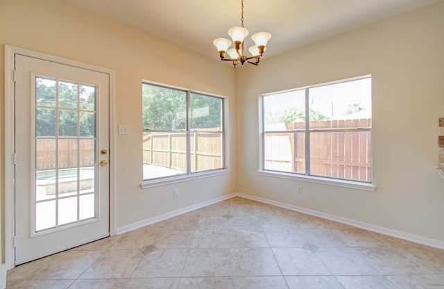 interior space with light tile patterned floors, a chandelier, and a wealth of natural light