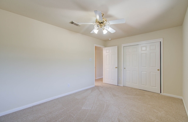 unfurnished bedroom with ceiling fan, a closet, and light carpet