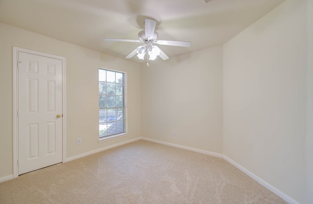 carpeted spare room with ceiling fan