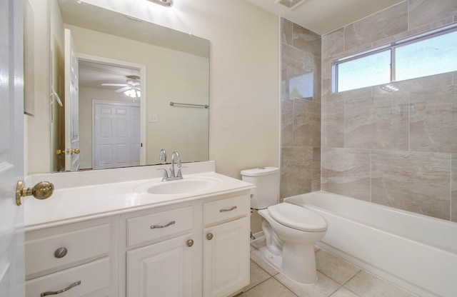 full bathroom with tile patterned flooring, vanity, ceiling fan, tiled shower / bath, and toilet