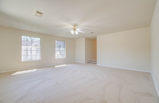 carpeted spare room featuring ceiling fan