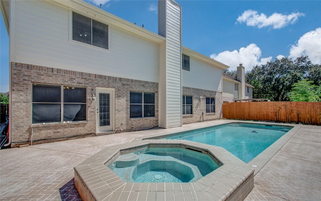 view of pool with a patio and an in ground hot tub