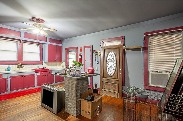 4995 Highland Ave, Beaumont, TX 77705 - kitchen with red cabinets, a ceiling fan, light wood-type flooring, and crown molding