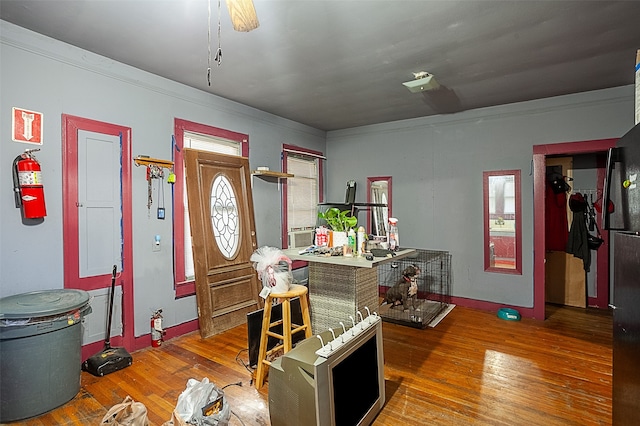 interior space with wood-type flooring, crown molding, and ceiling fan