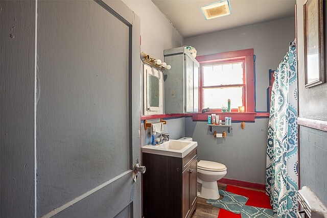 4995 Highland Ave, Beaumont, TX 77705 - full bathroom featuring vanity, toilet, wood finished floors, baseboards, and a shower with curtain