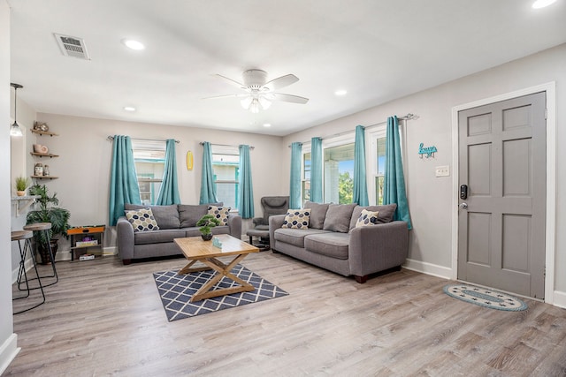 living room with light hardwood / wood-style floors and ceiling fan