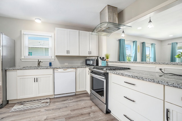 kitchen with white cabinets, island range hood, decorative light fixtures, light hardwood / wood-style flooring, and stainless steel appliances