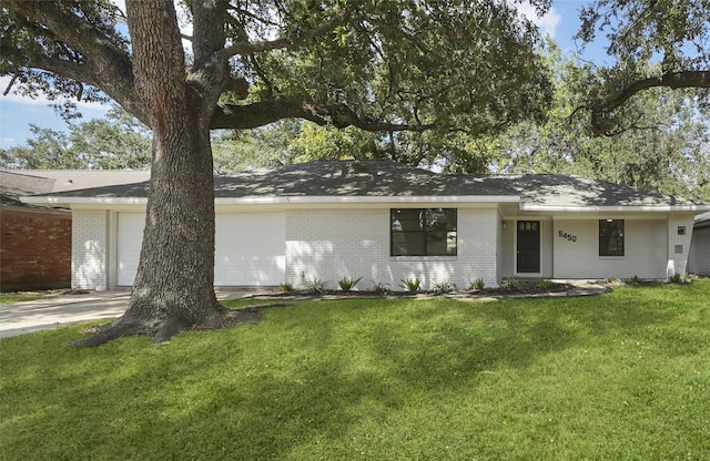 ranch-style house featuring a front yard and a garage