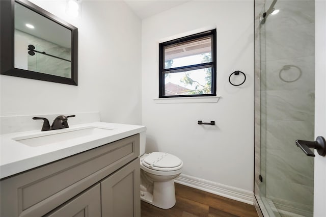 bathroom featuring hardwood / wood-style floors, vanity, toilet, and a shower with shower door