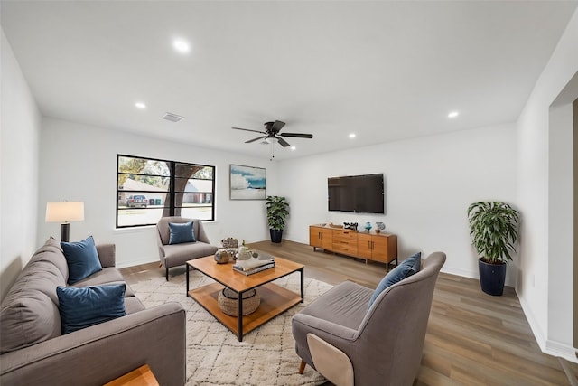 living room featuring light hardwood / wood-style floors and ceiling fan