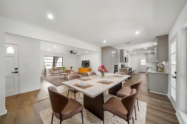 dining area with ceiling fan and wood-type flooring