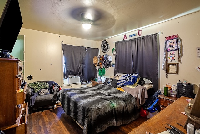 bedroom featuring ceiling fan, dark hardwood / wood-style floors, and a textured ceiling