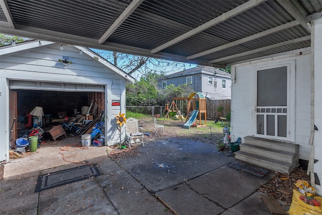 exterior space featuring a playground, a garage, and an outbuilding