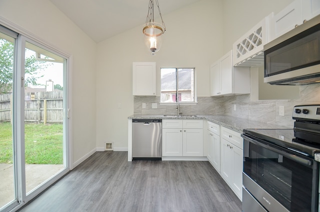 kitchen featuring vaulted ceiling, sink, stainless steel appliances, and white cabinets