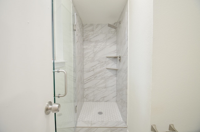 bathroom featuring a shower with door