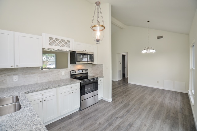 kitchen featuring white cabinets, stainless steel appliances, hanging light fixtures, and light hardwood / wood-style floors