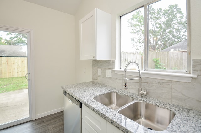 kitchen with light stone countertops, stainless steel dishwasher, sink, and white cabinets