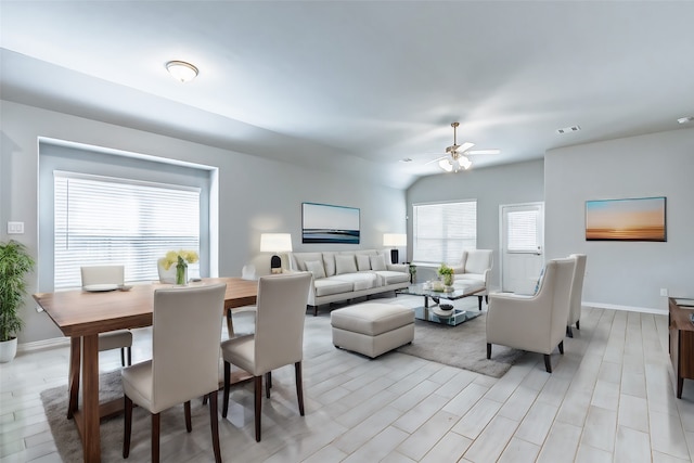 living room featuring ceiling fan, vaulted ceiling, and light hardwood / wood-style floors