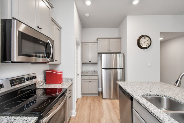 kitchen featuring gray cabinetry, sink, stainless steel appliances, and light hardwood / wood-style flooring