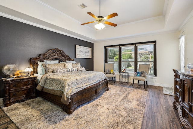 bedroom featuring ceiling fan, crown molding, and a tray ceiling