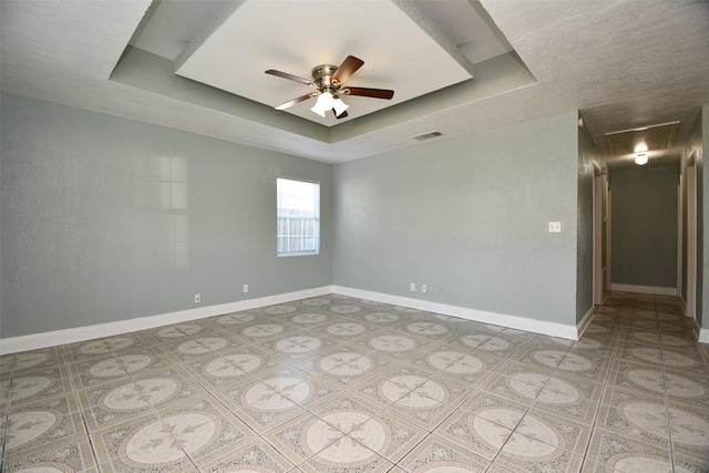 empty room with a tray ceiling and ceiling fan