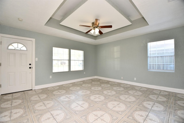 foyer entrance featuring a tray ceiling and ceiling fan