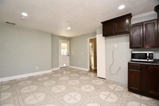 kitchen with dark brown cabinetry and a textured ceiling