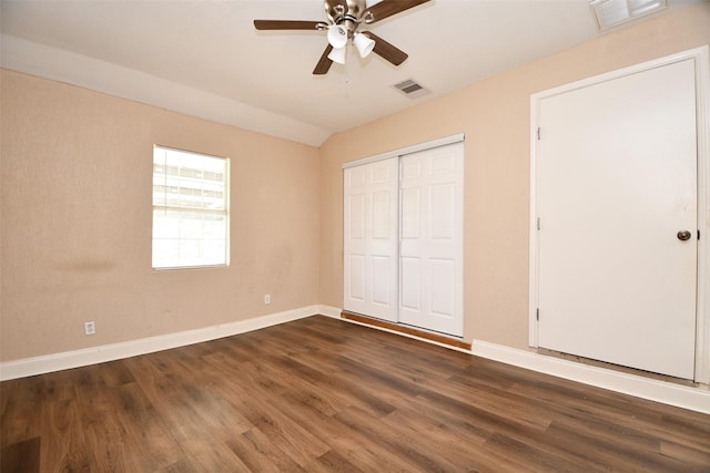 unfurnished bedroom with dark wood-type flooring, a closet, ceiling fan, and vaulted ceiling