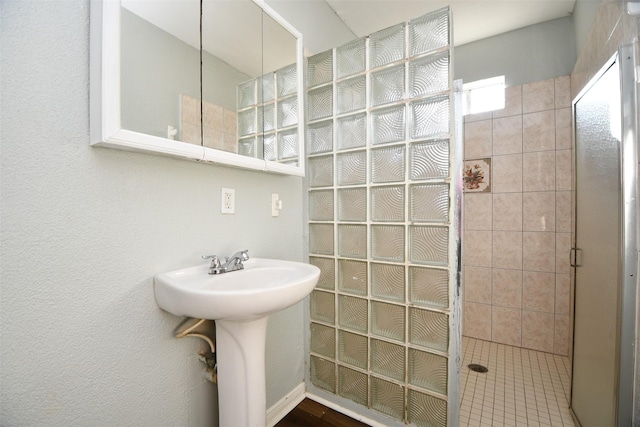 bathroom featuring tiled shower and sink