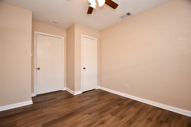 unfurnished bedroom with ceiling fan, dark hardwood / wood-style flooring, and a closet