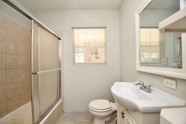 full bathroom with tile patterned floors, vanity, toilet, and enclosed tub / shower combo