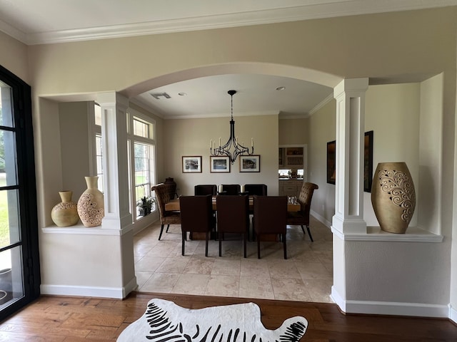 dining area with a chandelier, decorative columns, light hardwood / wood-style flooring, and ornamental molding