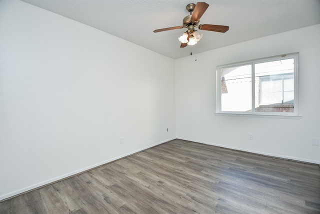 spare room featuring ceiling fan, a textured ceiling, and dark hardwood / wood-style flooring