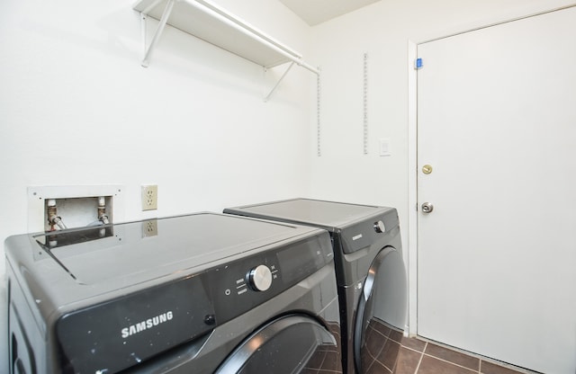 laundry room featuring independent washer and dryer and dark tile patterned floors