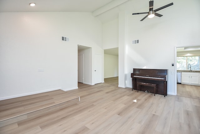 living room with light hardwood / wood-style floors, ceiling fan, beamed ceiling, and high vaulted ceiling