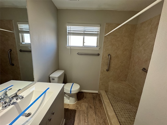 bathroom featuring hardwood / wood-style floors, vanity, toilet, and a shower with door