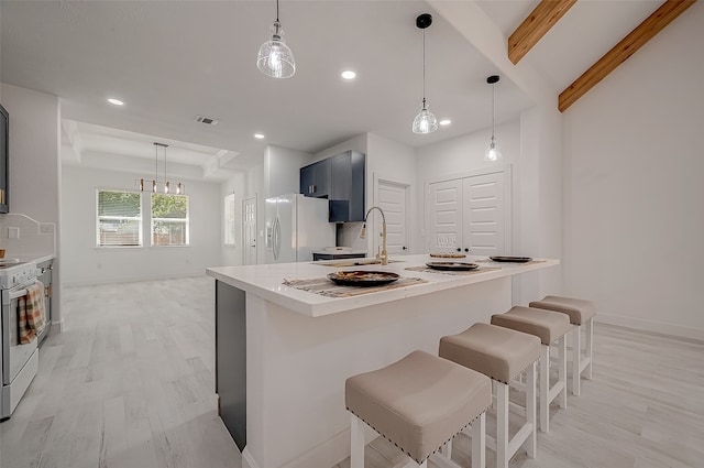 kitchen with hanging light fixtures, white appliances, and sink