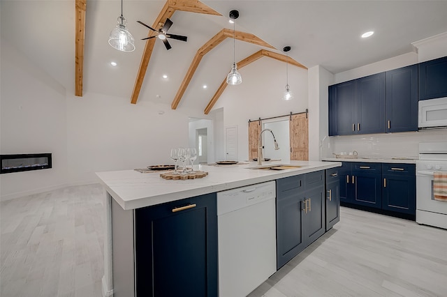 kitchen featuring sink, white appliances, a kitchen island with sink, blue cabinetry, and a barn door