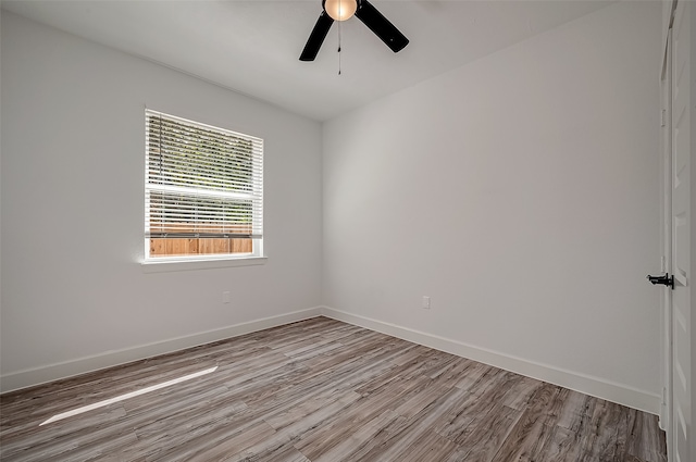 spare room with ceiling fan and light wood-type flooring