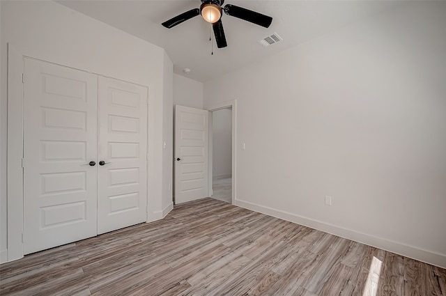 unfurnished bedroom featuring ceiling fan, a closet, and light hardwood / wood-style floors