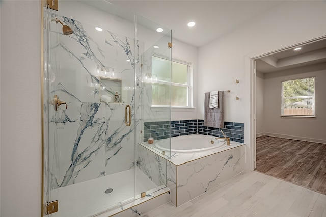 bathroom with hardwood / wood-style flooring and separate shower and tub