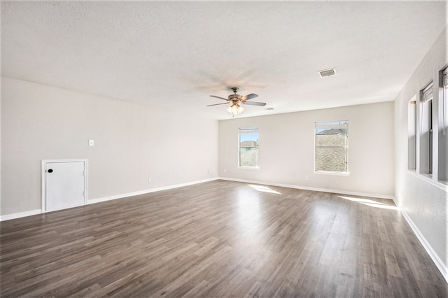 unfurnished room featuring a textured ceiling, dark wood-type flooring, and ceiling fan