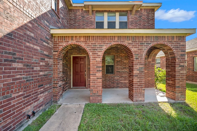 view of exterior entry featuring a yard