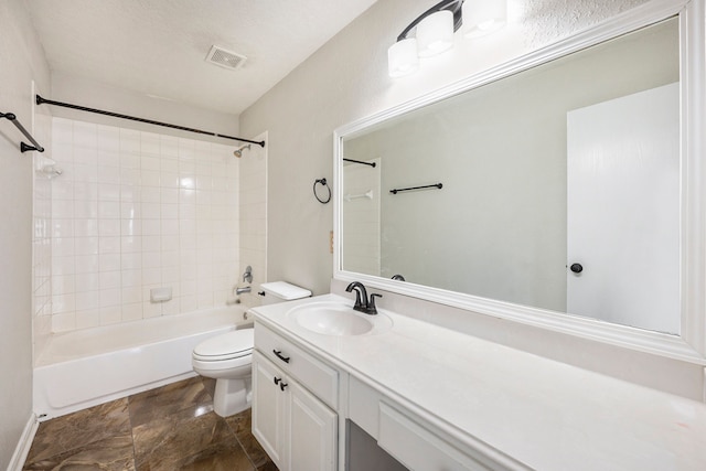 full bathroom with tiled shower / bath, vanity, toilet, and a textured ceiling