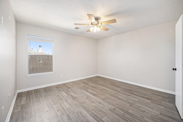 spare room featuring ceiling fan, a textured ceiling, and wood-type flooring