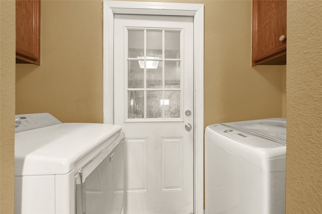 washroom featuring cabinets and washing machine and dryer