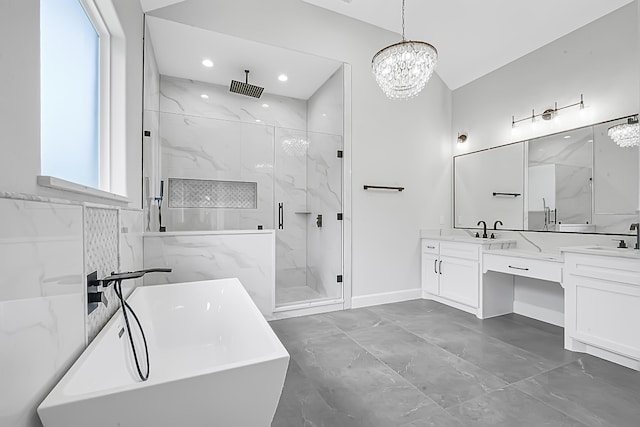 bathroom with vanity, separate shower and tub, and an inviting chandelier